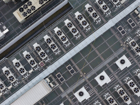 Aerial view of the AI datacenter rooftop featuring rows of industrial cooling units and ventilation systems in Warszawa, Wojewodztwo mazowieckie, Poland.
