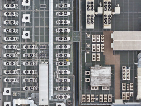 Aerial view of the rooftop of a modern datacenter featuring numerous industrial cooling units and ventilation systems in Warsaw, Wojewodztwo mazowieckie, Poland.