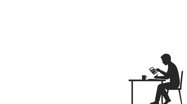 Silhouette of person sitting at desk using laptop