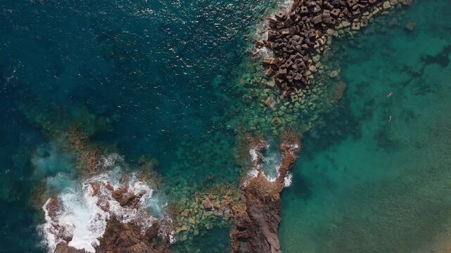 Drone descending toward Atlantic waves on volcanic coastline, Tenerife, Canary Islands
