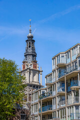 View of Amsterdam cityscape featuring historic architecture along Zwanenburgwal canal under a clear blue sky. © John