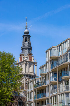 View of Amsterdam cityscape featuring historic architecture along Zwanenburgwal canal under a clear blue sky.