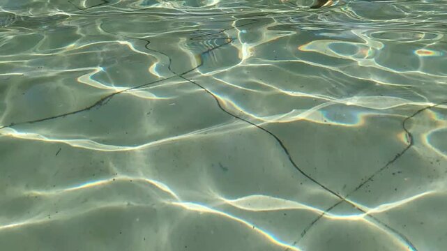 In the park, in the fountain, the sun glitters on the water and creates a slight ripple.