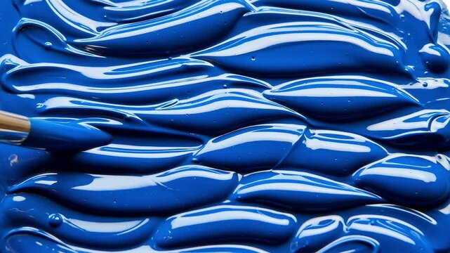 Thick textured blue acrylic paint strokes applied with artist brush on canvas