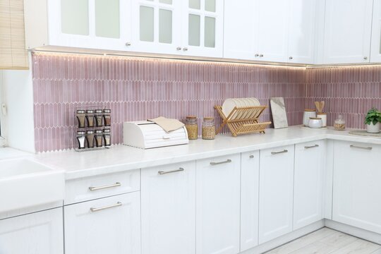 Breadbox, spices and dishware on counter in kitchen