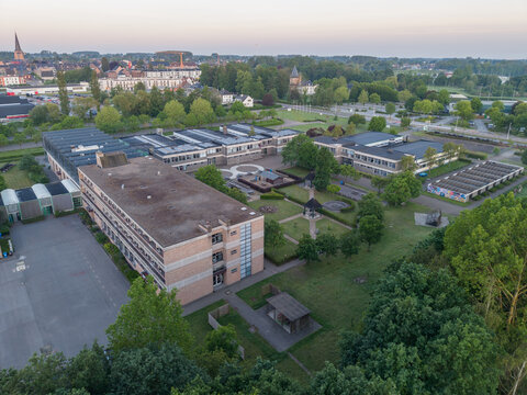 Diepenbeek, Belgium. Aerial drone view of Provincial School Diepenbeek campus with educational buildings and green surroundings at sunrise