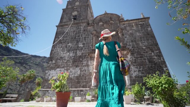 Senior woman enjoys the beauty of San Javier Mission in Loreto, Baja California Sur during sunrise and takes in the sights