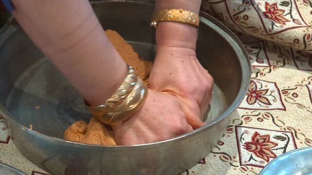 Authentic Turkish cuisine: Hands of a woman preparing the outer shell for i&ccedil;li k&ouml;fte in a metal tray.