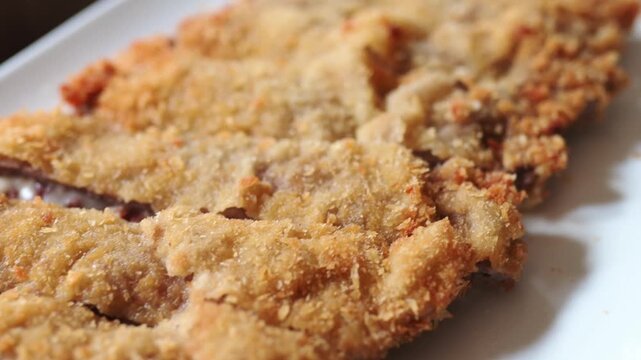 Close up view of a cachopo, a traditional spanish dish from asturias. Sliced breaded veal fillets stuffed with serrano ham and cheese