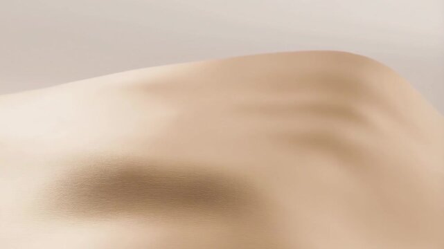 Slow panning tracking shot of sand dunes undulating across minimal desert landscape with soft textured ripples