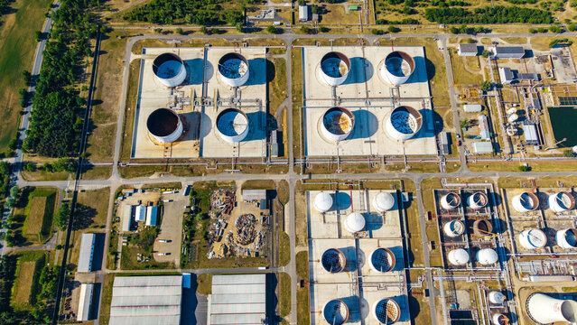 Aerial view of large industrial storage tanks and complex piping systems at the Unipetrol RPA refinery surrounded by green fields Kralupy nad Vltavou 1, Stredocesky kraj, Czechia.
