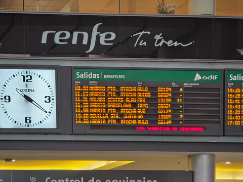 Renfe Train Station Departure Board with Information Screen and Analog Clock in Interior of Maria Zambrano Railway Station in Malaga
