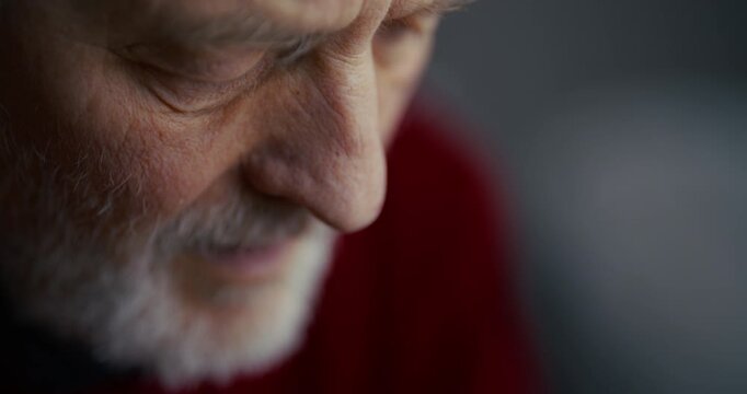 Thoughtful elderly bearded man in close-up with soft indoor light