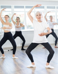 Obraz premium Graceful women of different ages practice various ballet movements in a choreographic studio