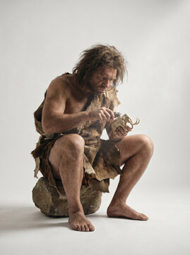 Caveman Carving a miniature mamooth With Stone Tool