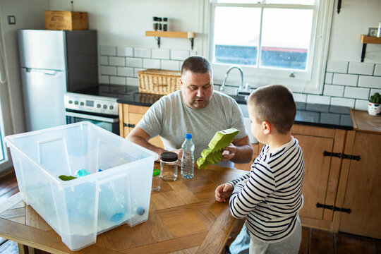 Father and son sorting recycling in kitchen