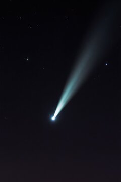 Bright comet illuminates dark night sky full of stars. Tail stretches across vast universe. Celestial body glows intensely, beautiful natural spectacle in deep space. Astronomical sight offers wonder.
