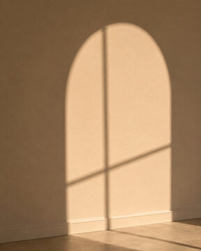 Soft arched window shadow cast across a taupe wall and floor in warm sunlight, creating a minimal interior background with calm architectural light and copy space.