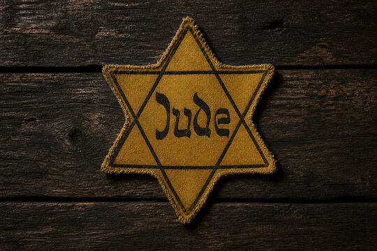 Yellow star badge labeled jude placed on dark wooden background