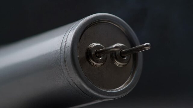 Slow motion shot of generic capacitor discharging a single bright blue electric spark physics animation