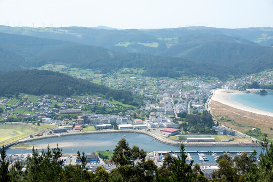 Panoramic view of Viveiro town, estuary, and beach from the San Roque viewpoint (Mirador de San Roque) in Galicia, Spain. A scenic landscape with coastal buildings, hills, and a harbor.