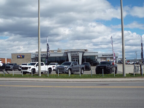 Gatineau, Quebec, Canada &ndash; May 7, 2026: The "Buick GMC Lachapelle" dealership building is shown across a road with several pickup trucks parked out front at 900 Boulevard Saint-Joseph.