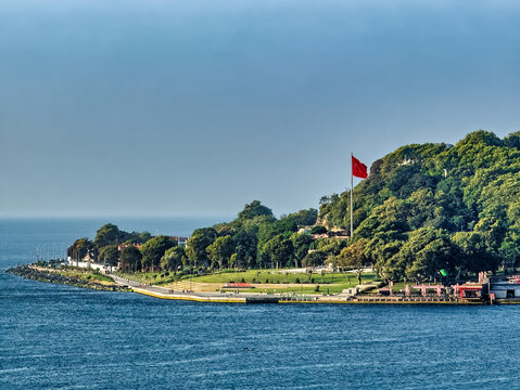 Istanbul, Turkey - July 21, 2024: City views. IBB Sarayburnu Park at the confluence of Golden Horn and the Bosphorus. Sea of Marmara on horizon. Red national flag at Ataturk memorial