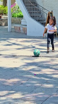 Latina girl playing soccer in the park