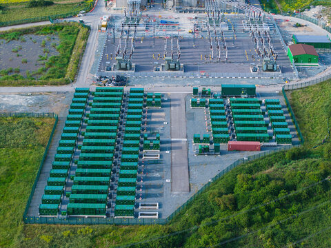 Aerial view of Thurrock Battery Energy Storage BESS and Flexible Generation Plant with rows of green battery units and electrical infrastructure in Thurrock, England, United Kingdom.
