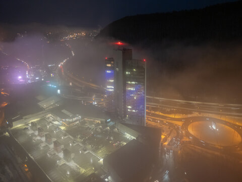 Aerial view of Europa SC and Europa Business Center at night with fog rolling over the city and illuminated streets in Banska Bystrica, Banskobystricky kraj, Slovakia.