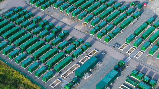 Aerial view of the Thurrock Battery Energy Storage BESS and Flexible Generation Plant with rows of green storage units on a gravel site in Thurrock, England, United Kingdom.