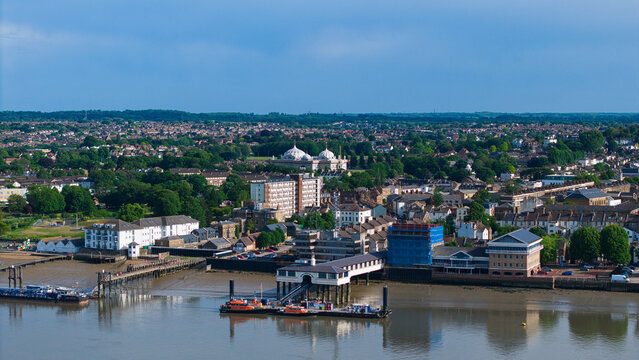 Aerial view of the Gravesend waterfront featuring the Town Pier on the River Thames and the Guru Nanak Darbar Gurdwara domes in the distance Gravesend, England, United Kingdom.