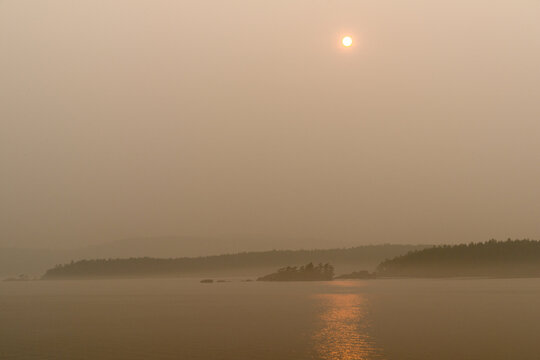 Canada, BC, Gulf Islands,  The sun and the view obscured by forest fire smoke