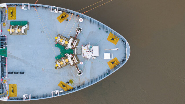 Aerial view of the bow of a large cargo ship on the River Thames showing deck machinery and safety markings London, Greater London, United Kingdom.