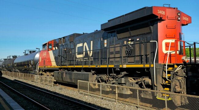 Powerful CN Freight Locomotive on Railway Tracks Under Clear Blue Sky in Modern Transport Scene