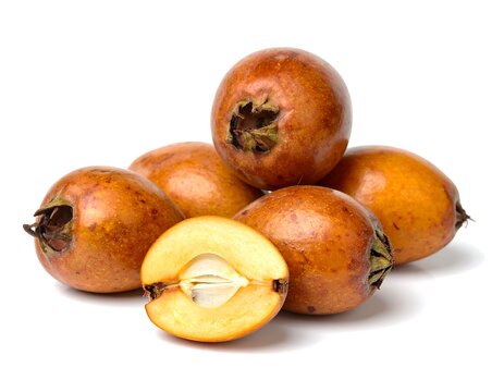 Organic medlar fruits, whole and halved, with visible seeds on white background