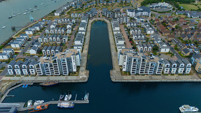 Aerial view of Saint Mary's Island featuring modern residential buildings surrounding a central water basin and marina with boats Rochester, England, United Kingdom.