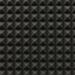 Fototapeta premium Black acoustic foam panel with pyramid-shaped wedges. This textured surface is great for soundproofing studios. It offers sound absorption for a quiet space.