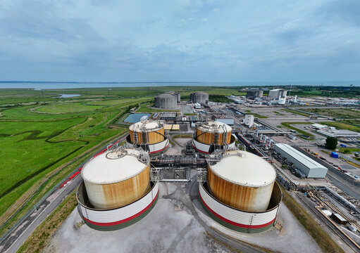 Aerial view of Grain LNG terminal featuring large storage tanks and industrial infrastructure surrounded by green fields and coastal landscape in Wallend, England, United Kingdom.
