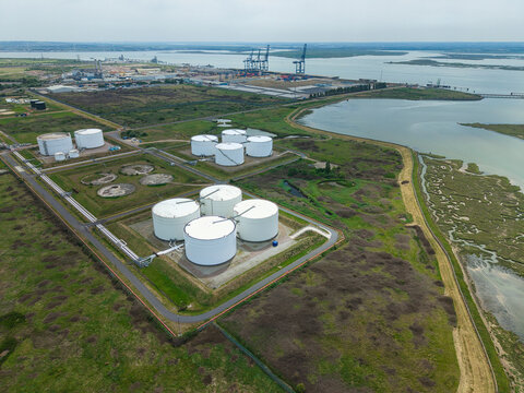 Aerial view of Grain LNG storage tanks and industrial infrastructure surrounded by coastal marshland and port facilities in Wallend, England, United Kingdom.