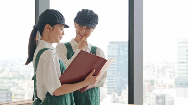 店内でファイルを見る飲食店店員