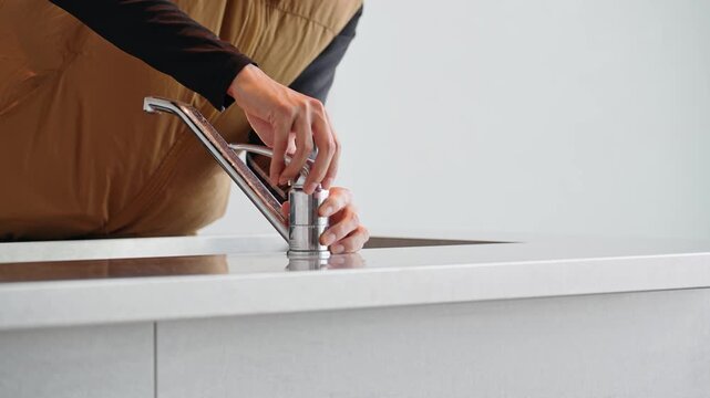 水道の蛇口を点検する作業員