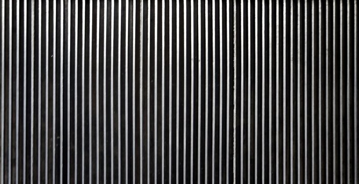 Dark metallic vertical lines texture background. Black and silver parallel metal ridges pattern, escalator step tread closeup, industrial design abstract.