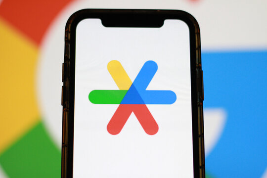 Google Assistant application displayed on smartphone screen with colorful digital background, mobile AI and voice technology concept