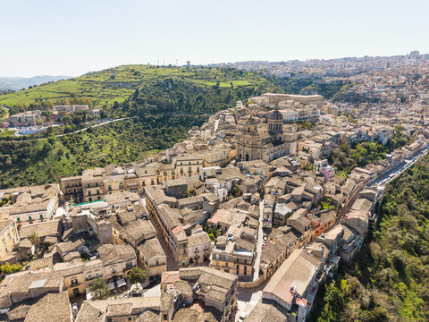 Aerial view of the historic old town of Ragusa Ibla with its stone buildings and the majestic Duomo di San Giorgio under a clear sky Ragusa, Sicily, Italy.