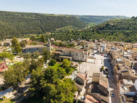 Aerial view of the historic town of Ragusa Ibla featuring the Church of San Giacomo, stone buildings, and a public square nestled in a lush green valley in Ragusa, Sicily, Italy.