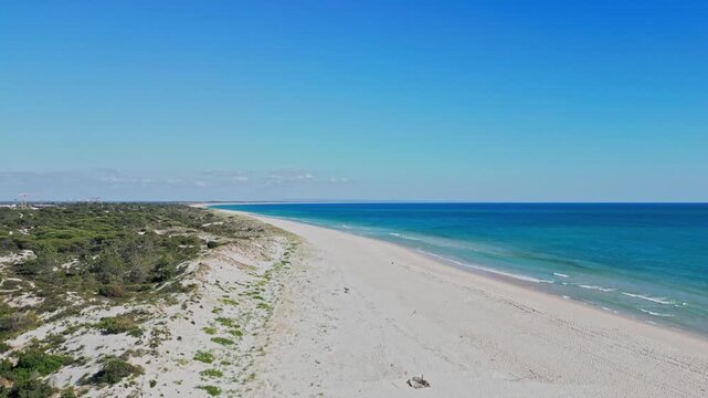 Pristine, empty white sand beach and turquoise ocean in Comporta, near Lisbon, Portugal. Perfect for travel, vacation, and summer concepts, aerial views