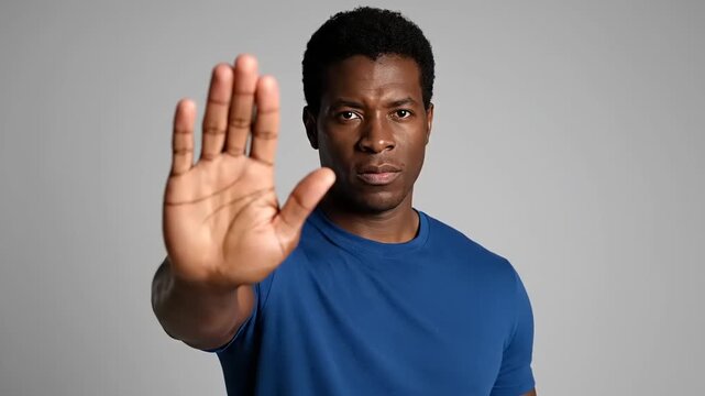 Serious man with outstretched hand signals a firm stop or warning, emphasizing a boundary or refusal in a compelling manner, conveying clear communication