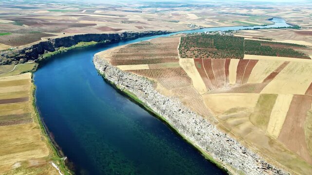 Aerial view of Euphrates river flowing through rural agricultural landscape in Turkey.