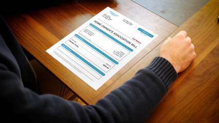 Fototapeta premium A Stressed Adult Looks at a HOA Home Owners Association Bill